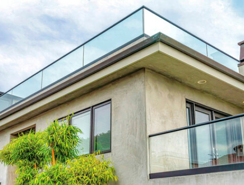 Building with glass railing on balcony and roof