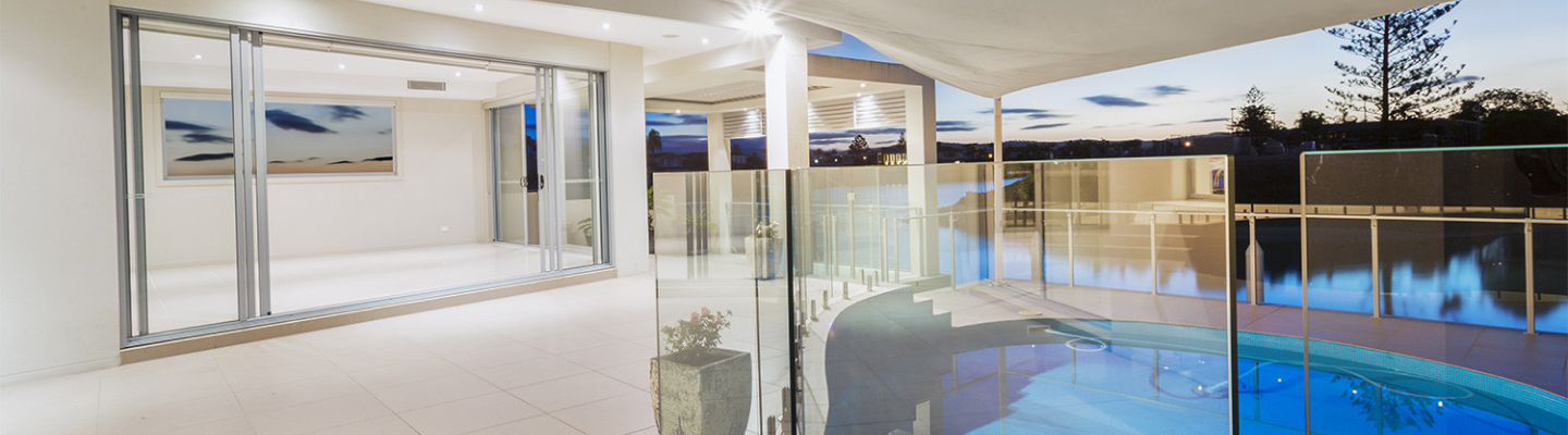 Modern pool surrounded by a glass paneled railing