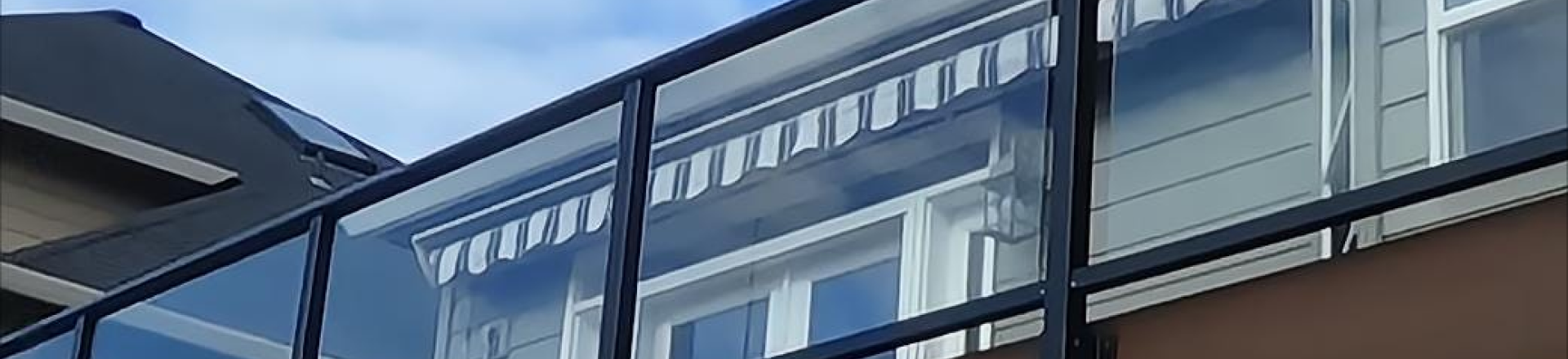 Cropped shot of glass railings with black metal framing