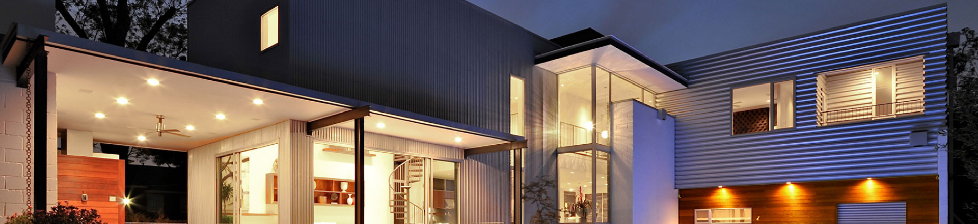 Modern home exterior warmly illuminated at night