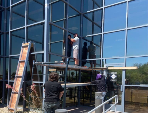 Workers on scaffolding working on windows at an office building