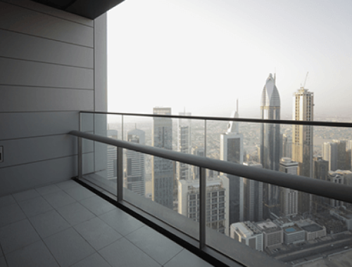 City skyline from balcony perspective behind a glass railing