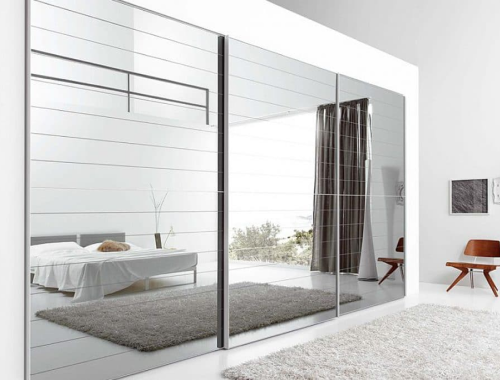 Bedroom with mirrored panels on wall