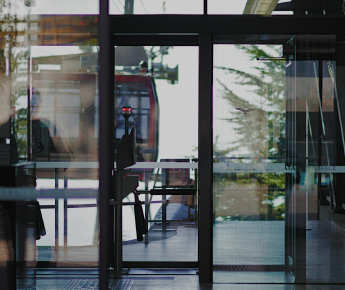 Commercial office building with glass windows and doors onto an outdoor balcony