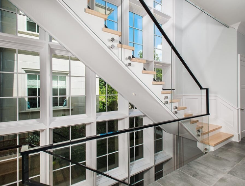 Modern and bright stairwell with large windows to outside and glass railings