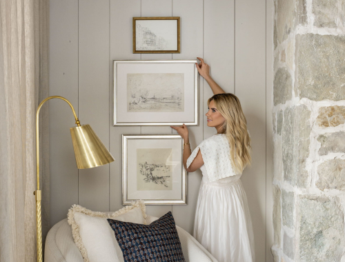 Woman hanging a picture on a wall