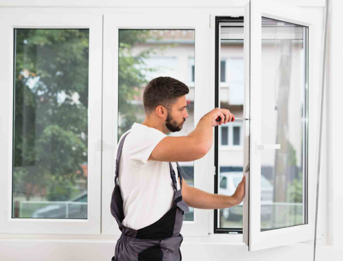 Worker screwing window frame